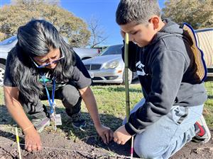 student with teacher in the dirt